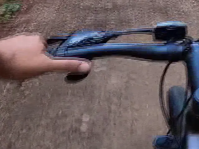 Upscaled interlaced frame: horizontal comb lines along the handlebar and hands